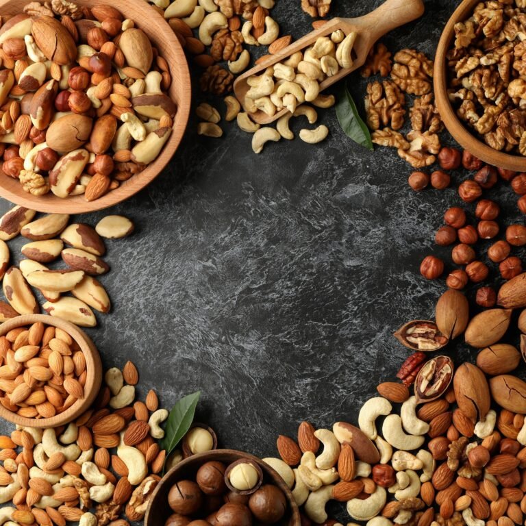 Bowl and wooden scoop with different nuts on black smokey background